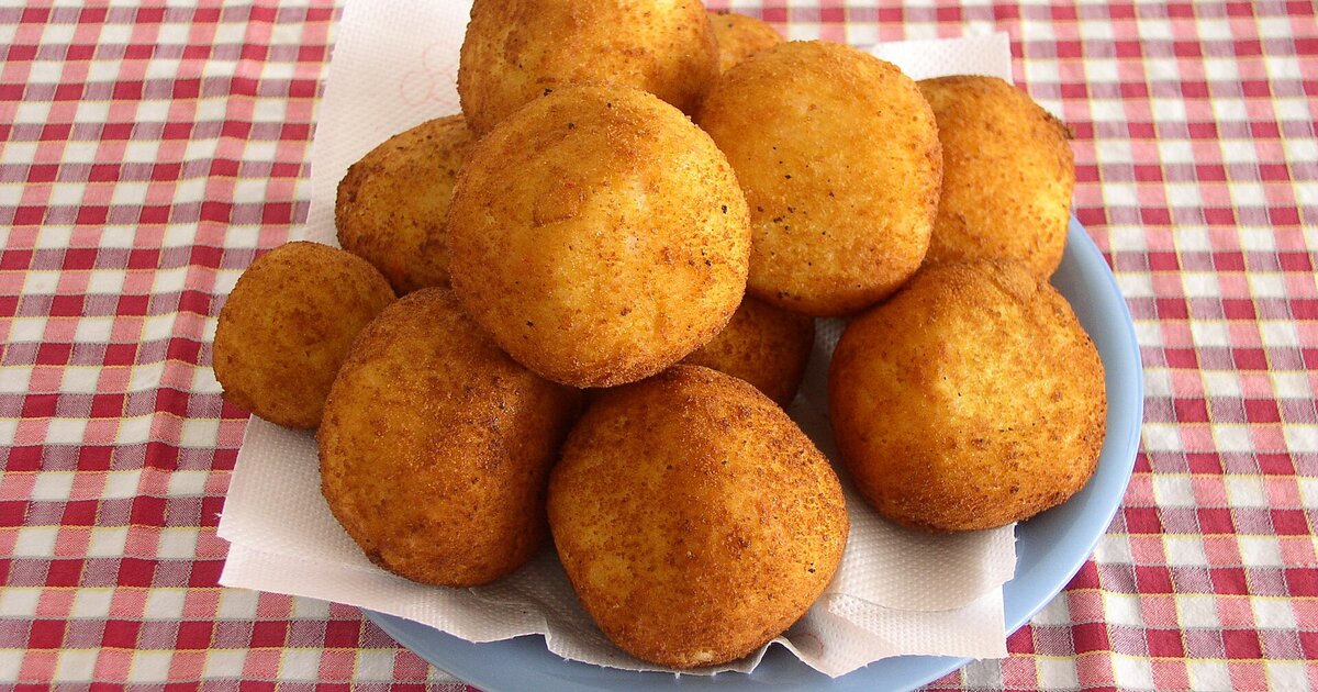 Un piatto di arancini fritti, lo street food simbolo di Catania